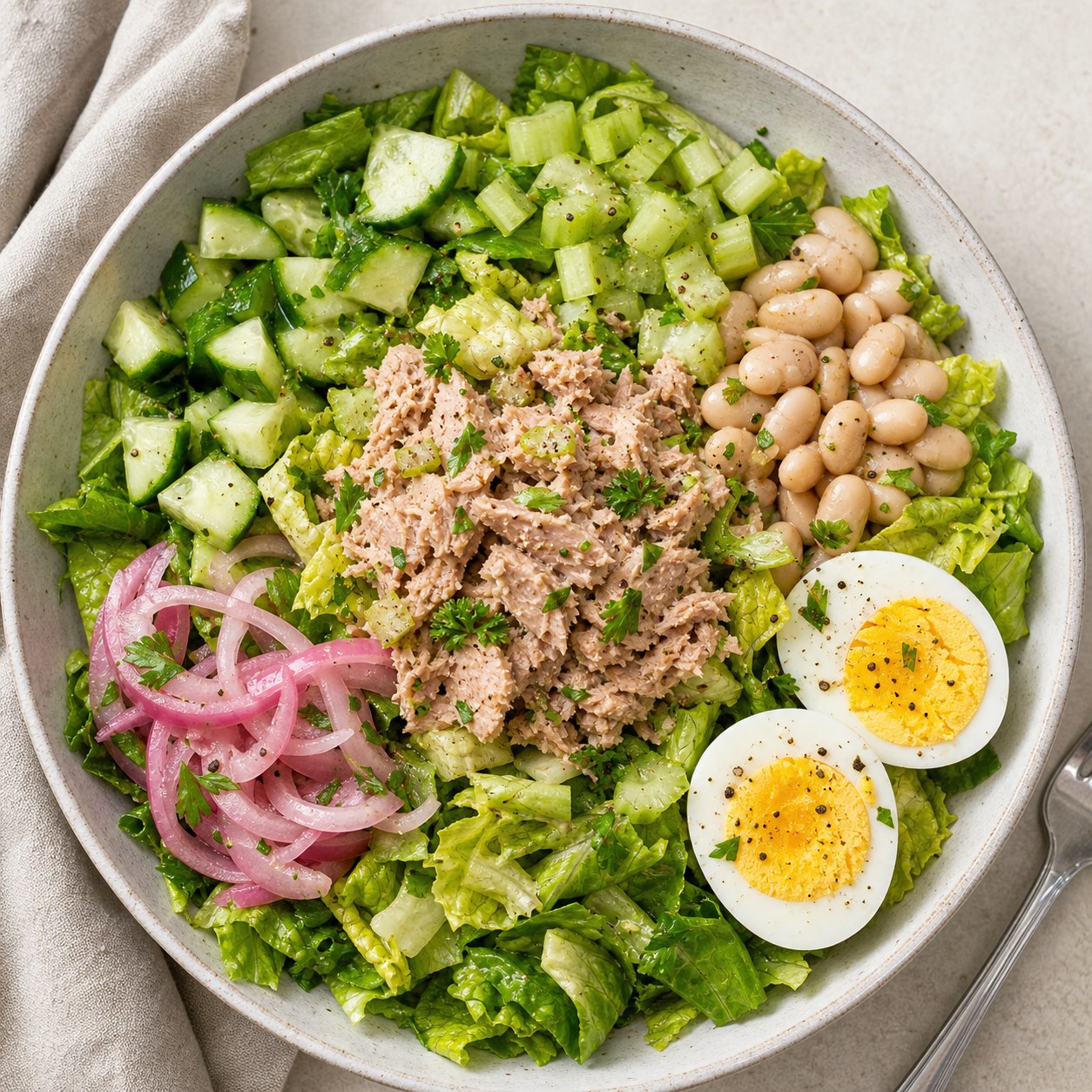Tuna crunch salad bowl with romaine, egg, white beans, and herbs